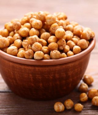 Roasted chickpeas in bowl on wooden table