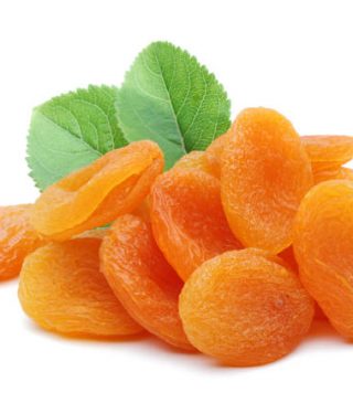 Dried apricots with leaves isolated on white background